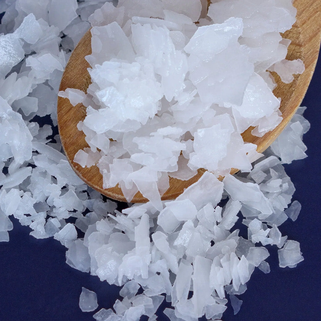 a spoon with Aria Black Magnesium Bath Flakes