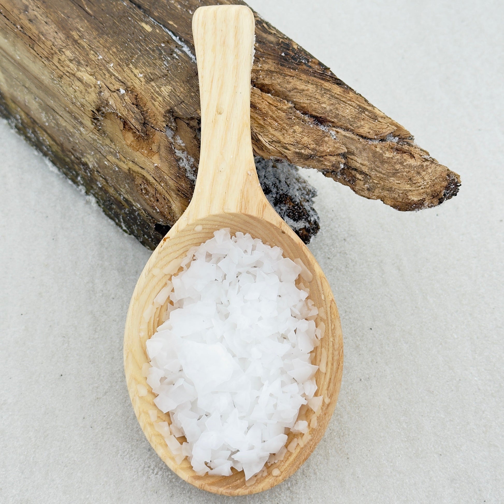 an image of pure Magnesium Flakes in a wood spoon on a beach