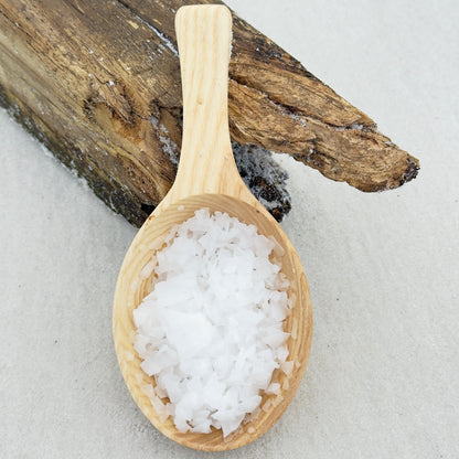 an image of pure Magnesium Flakes in a wood spoon on a beach